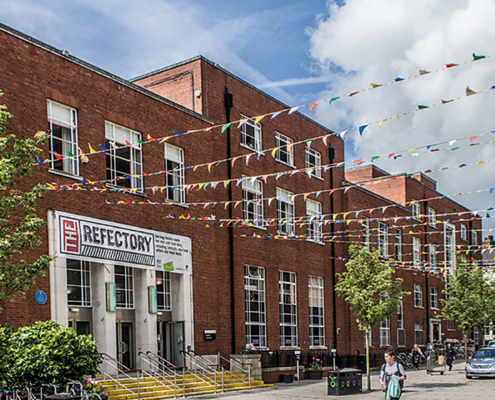 The Refectory building exterior in the sunshine with bunting